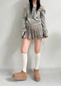 Close-up detail of white slouchy over-the-knee socks, perfect for cozy winter daily outfits.