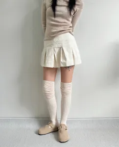 Detailed view of women's white ribbed slouch socks, cozy over-the-knee autumn style.