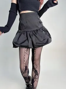 Detailweergave van zwarte opengewerkte visnetpanty's en een stijlvolle ballonrok voor dames.