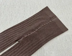 Détail collants maille torsadée marron, texture collant hiver rétro, design thermique chaud.