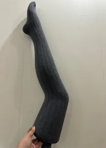 Gros plan détail de collants gris foncé en tricot, montrant une texture douce et élastique.