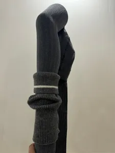 Détail de collant tricoté gris foncé, beau motif torsade chaud d'hiver avec jolies jambières rayées.