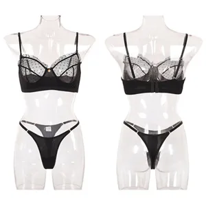 Schwarzes Spitzen-Mesh-Wäscheset mit einem Schick-BH und Tanga mit zarten Punktmustern.