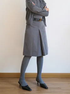 Grey knit cardigan and stirrup tights detail shot, soft fabric and elegant winter outfit look.