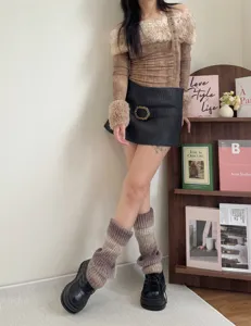 Detail shot of gradient knit leg warmers styled with autumn outfit and book shelf background.