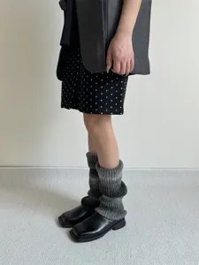 Detailed shot of gradient slouch socks worn with black shoes, showcasing cozy winter style.