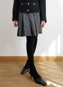 Close-up detail shot of women's autumn winter vintage tweed outfit with black tights.