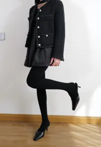 Detailed shot of women's autumn winter black thick tights paired with tweed jacket outfit