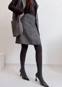 Vista detallada de medias térmicas afelpadas para mujer combinadas con falda y tacones.
