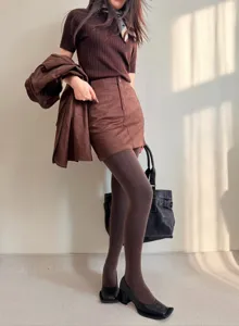 Vista detallada de medias térmicas para mujer combinadas con un elegante top de punto marrón.