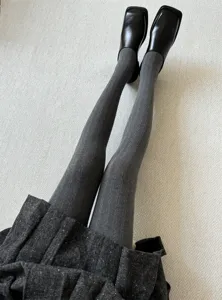 Gros plan détail de collants gris texturés assortis à des chaussures noires pour la saison.