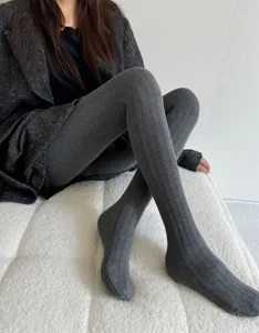 Gros plan sur des collants en tricot côtelé gris pour femmes automne hiver texture douce.