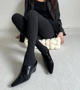 Collants côtelés noirs d'automne avec chaussures à talons compensés et blazer chic.