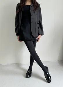 Vue détaillée de collants texturés en tricot associés à des mocassins rétro et un blazer.