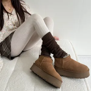Bottes de neige marron à plateforme avec chaussettes en tricot et collants thermiques.