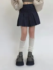 Detailed view of distressed knitted leg warmers with tassel design, showcasing texture and style.