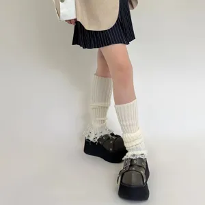 Close-up of distressed knitted leg warmers with tassels, featuring a trendy Y2K wasteland style.