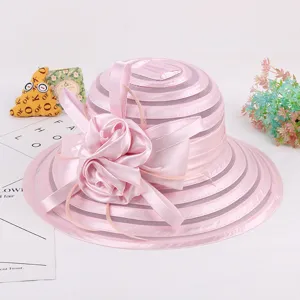 Detail view of the pink organza sun hat, showing the delicate flower bow and sheer brim texture.