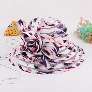 Close-up detail of the elegant organza sun hat featuring abstract print and large flower decor.
