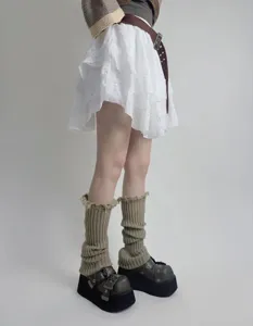 Detailed close-up of knitted leg warmers featuring distressed tassel design for autumn.