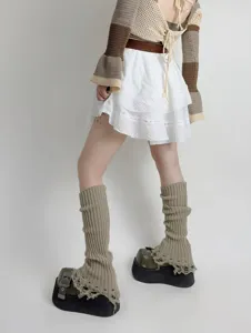 Knitted tassel leg warmers detail shot, grunge style distressed slouch socks for autumn winter.