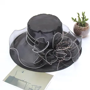 Close-up details of the black organza flower decoration and fine silver piping on the hat brim.