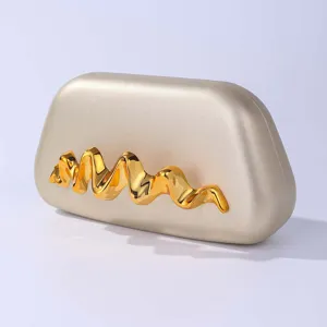 Λεπτομέρεια χρυσής βραδινής τσάντας clutch, με μοναδικό μεταλλικό κυματιστό σχέδιο.