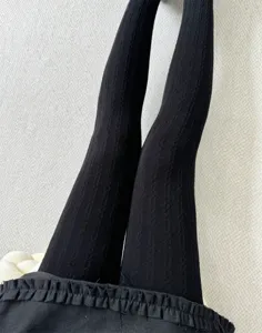 Vue detaillee de collants thermiques noirs d'hiver en tricot cable pour les femmes.