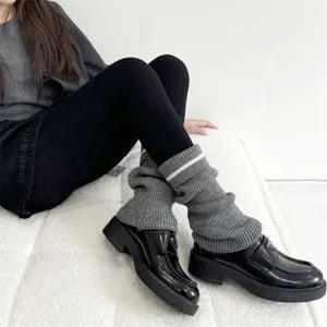 Collants noirs d'automne hiver assortis avec des jambières en tricot gris et mocassins.