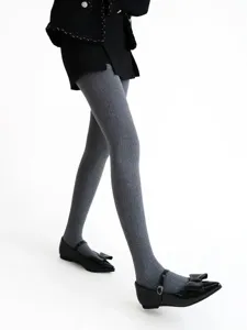 Detail shot of thick grey ribbed tights with vintage dark texture, ideal for winter.