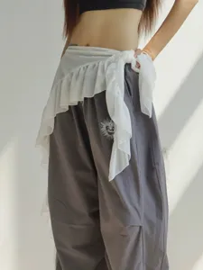 Detail shot of grey cargo pants with white sheer wrap skirt, stylish street dance hip scarf.
