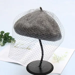 Close-up of the elegant grey wool beret with mesh veil, showcasing fine texture and retro style.