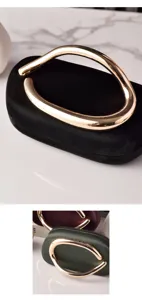 Black evening bag detail, vintage PU leather round clutch with golden abstract handle.