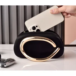 Elegant black evening clutch bag with striking gold metal handle, stylish fashion purse.