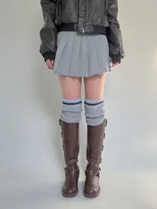 Scaldamuscoli in maglia stile college vista dettaglio con abbigliamento invernale a righe.