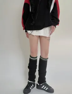 Vista dettagliata di scaldamuscoli in maglia stile college con doppia riga per outfit invernali.