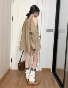 Dettaglio di scaldamuscoli in maglia a righe stile college vintage indossati in interni.