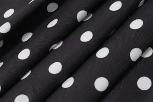 Gros plan détaillé du tissu classique à pois noirs et blancs avec texture côtelée fine.