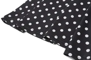 Vue détaillée de l'ourlet de la robe à pois noirs et blancs, texture du tissu et jolis plis.