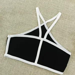 Black and white contrast cross halter crop top featuring rib knit fabric and open back design.