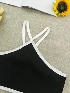 Close-up detail of black and white ribbed knit crop top with stylish double crisscross straps.