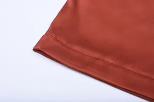 Close-up detail showcasing the smooth satin fabric hem and exquisite fine stitching of the dress.