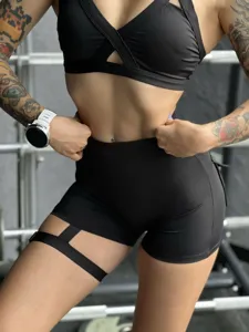 Detailaufnahme schwarzer High-Waist Fitnessshorts mit seitlichem Beindetail und Sport-BH.