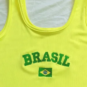 Primo piano della canotta a coste giallo neon con ricamo BRASIL verde e dettaglio bandiera.
