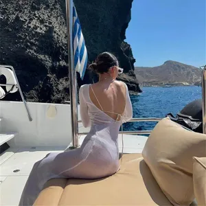 Detail view of a sexy backless white mesh long-sleeve beach dress for summer vacation.