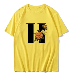 Yellow short sleeve t-shirt featuring a large black letter H print with vintage floral style.
