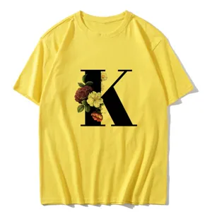 Close up detail of the yellow short sleeve t shirt featuring a bold letter k and vintage floral print.