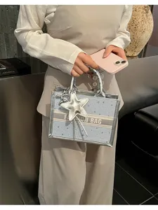 Silver star tote bag detail view, stylish PU leather handbag with star charm and strap.