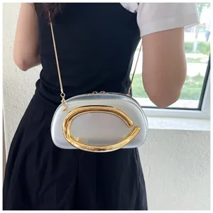 Gros plan sur les détails du sac bandoulière argenté élégant avec un accent métallique doré.