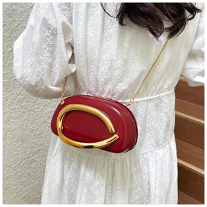 Vue détaillée du sac porté épaule rouge style rugby avec poignée et chaîne en métal doré.
